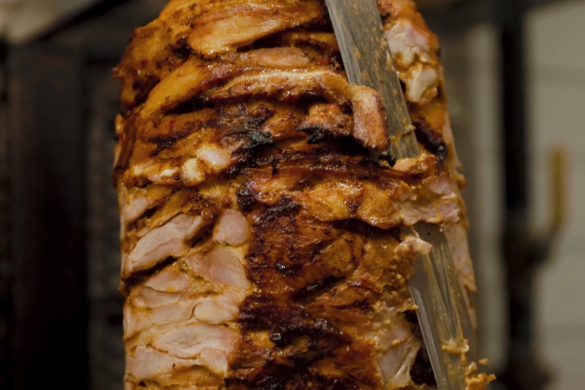 osoba seče šavarmu